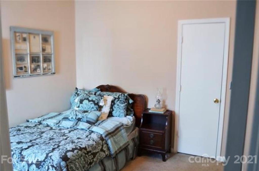 8311 Springhead Lane Charlotte, NC 28215 - Photo 8 of 11 a bed sitting in a bedroom next to a window