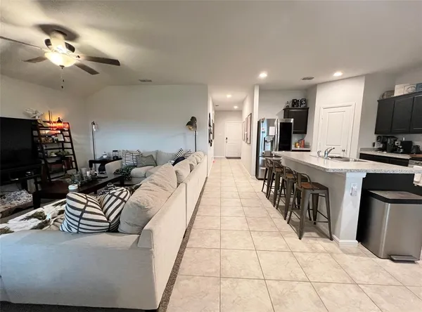 a living room with furniture a flat screen tv and a kitchen