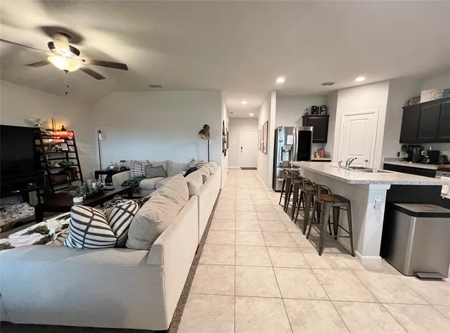 a living room with furniture a flat screen tv and a kitchen