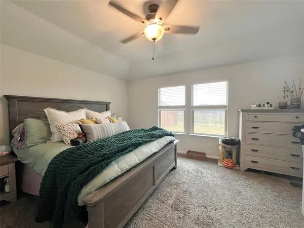 a bedroom with a bed and a ceiling fan