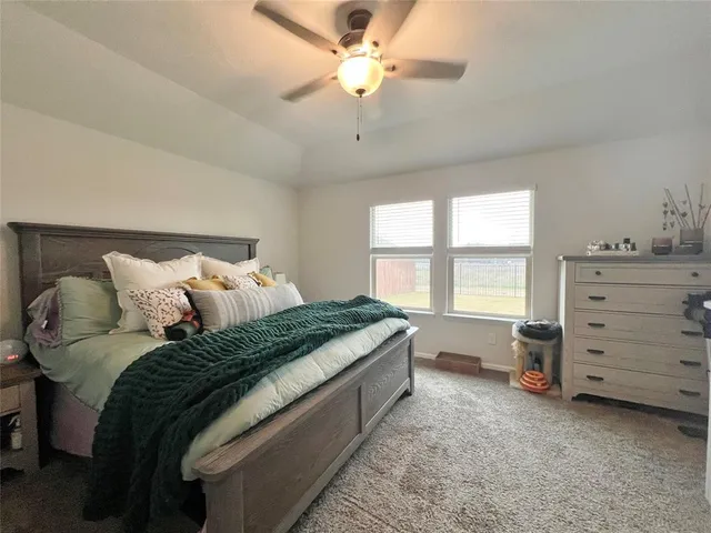 a bedroom with a bed and a ceiling fan
