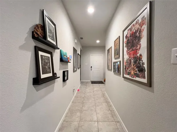 a view of a hallway with wooden floor and windows