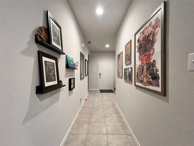 a view of a hallway with wooden floor and windows