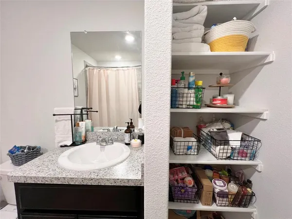 a bathroom with a granite countertop sink and a mirror