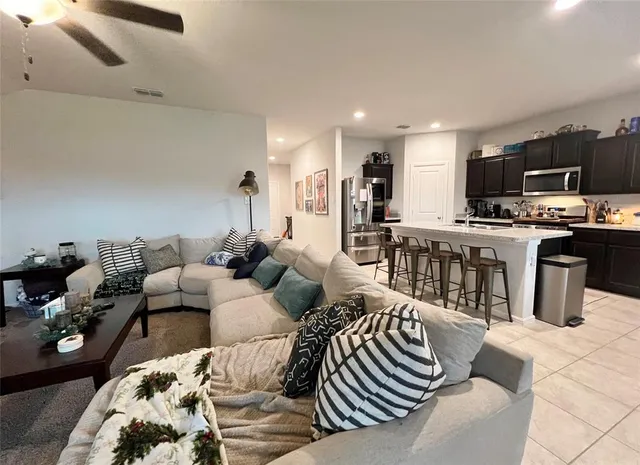 a living room with furniture a flat screen tv and kitchen view