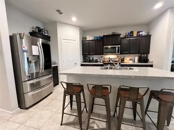 a kitchen with stainless steel appliances a refrigerator and a stove top oven
