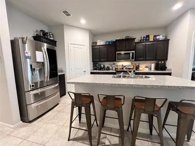 a kitchen with stainless steel appliances a refrigerator and a stove top oven