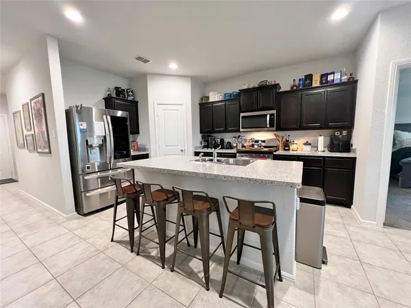 a kitchen with stainless steel appliances a stove a sink refrigerator and a microwave