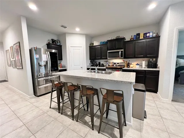 a kitchen with stainless steel appliances a stove a sink refrigerator and a microwave