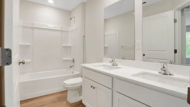 a bathroom with a sink a toilet and a large mirror