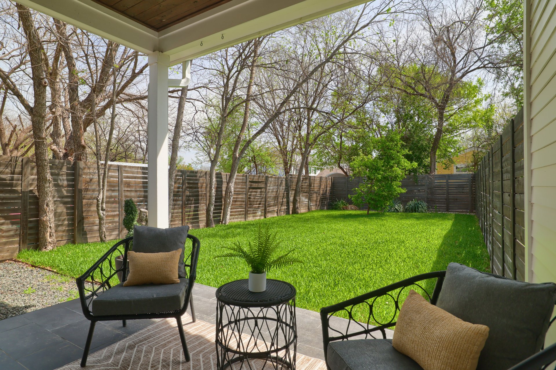 1103 Saucedo Street, Unit B Austin, TX 78721 - Photo 22 of 26 The covered back patio offers a shaded, private spot for morning coffee or outdoor dining while looking out over the mature trees