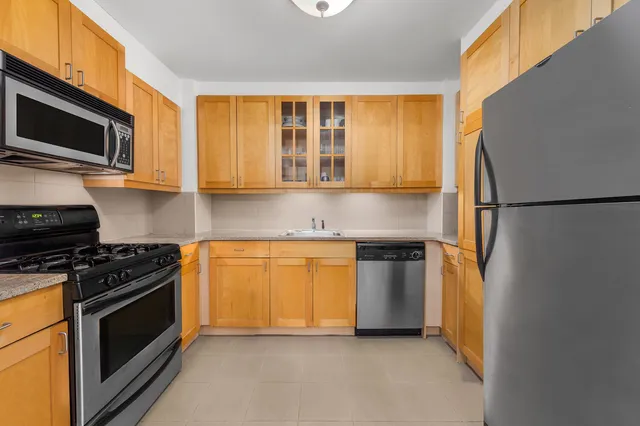a kitchen with stainless steel appliances granite countertop a stove a refrigerator and a microwave