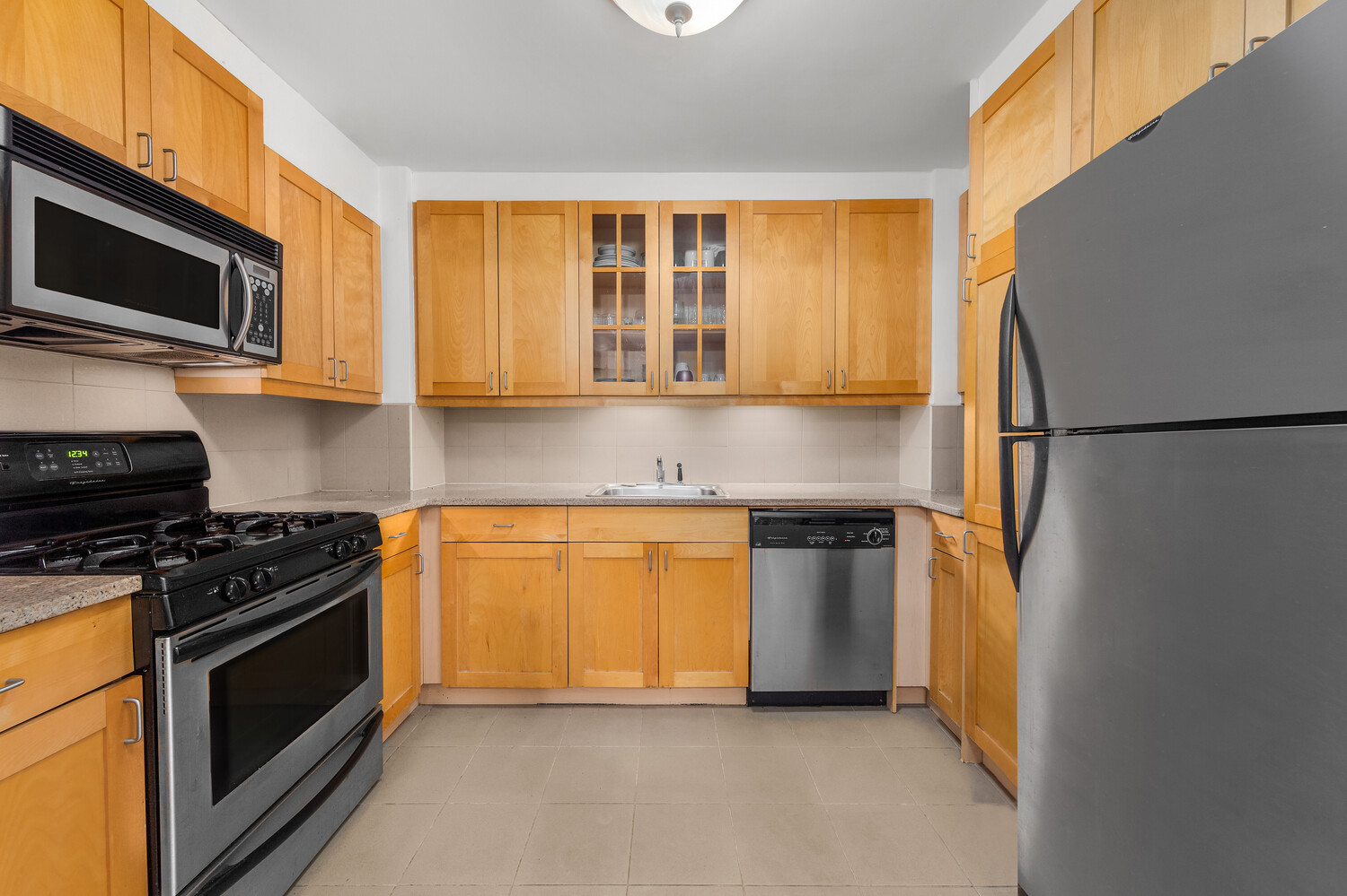845 2nd Avenue, Unit 6B Manhattan, NY 10017 - Photo 4 of 7 a kitchen with stainless steel appliances granite countertop a stove a refrigerator and a microwave