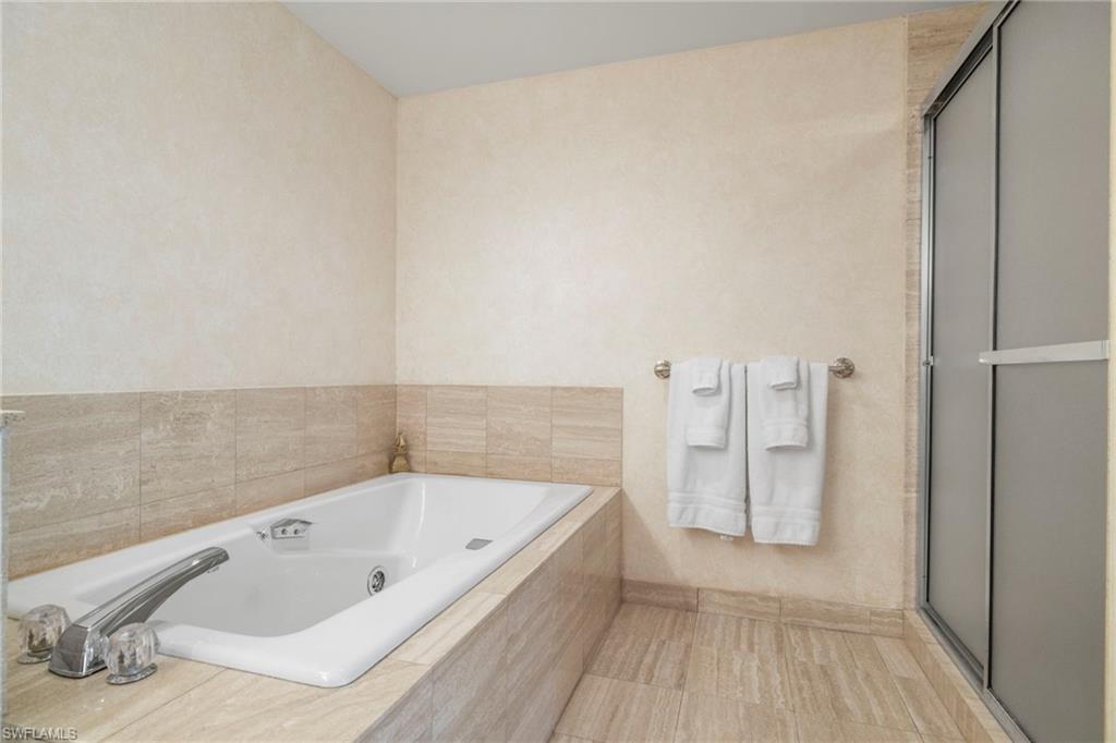 4451 Gulf Shore Boulevard North, Unit 2002 Naples, FL 34103 - Photo 16 of 42 a bathroom with a tub and shower
