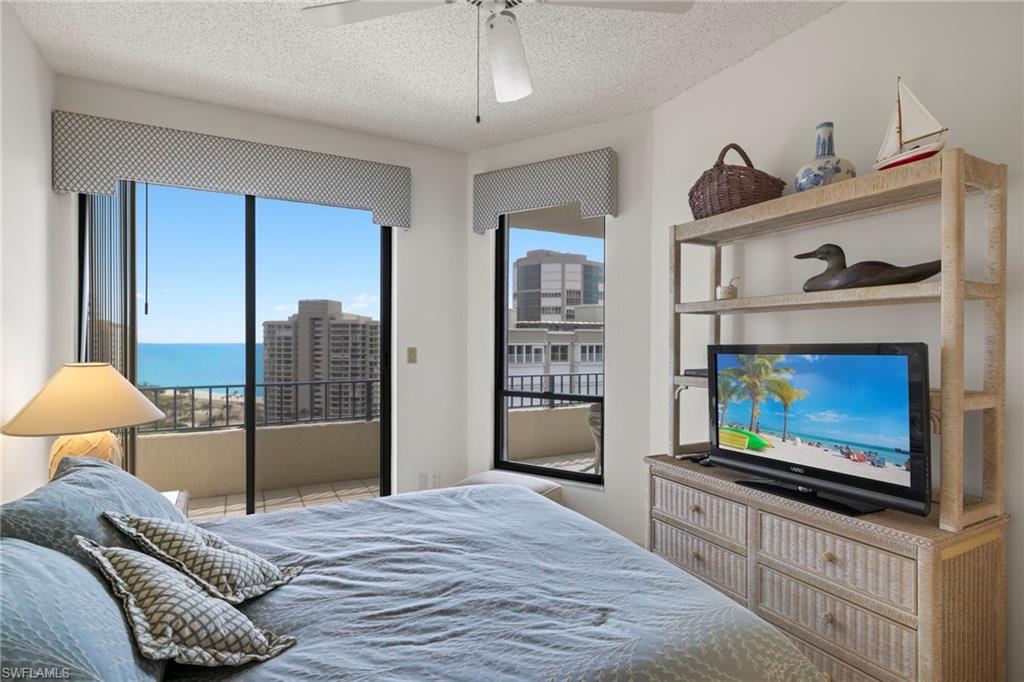 4451 Gulf Shore Boulevard North, Unit 2002 Naples, FL 34103 - Photo 17 of 42 a bedroom with furniture and a flat screen tv
