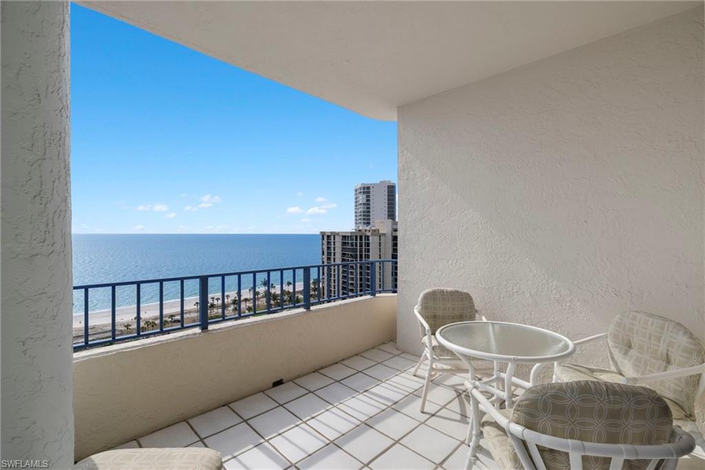 4451 Gulf Shore Boulevard North, Unit 2002 Naples, FL 34103 - Photo 4 of 42 a balcony with table and chairs