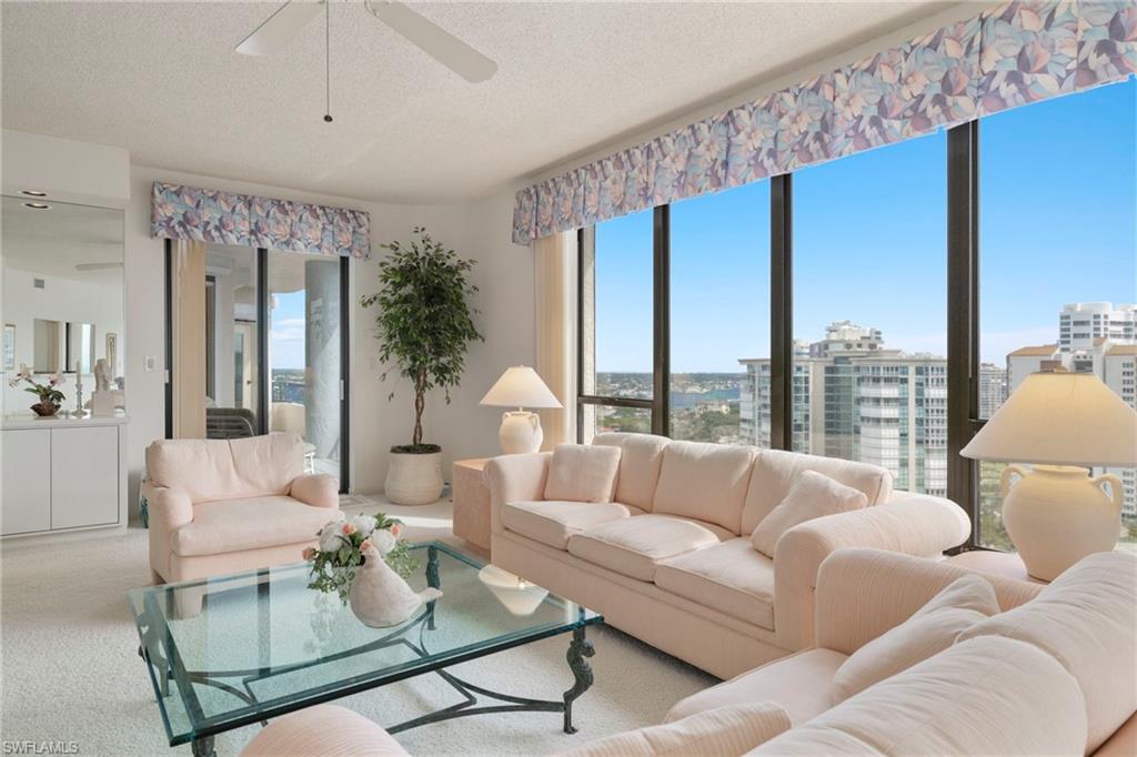 4451 Gulf Shore Boulevard North, Unit 2002 Naples, FL 34103 - Photo 6 of 42 a living room with furniture large windows and wooden floor