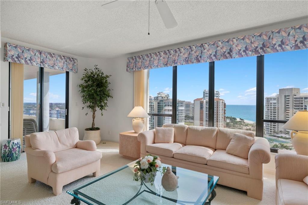 4451 Gulf Shore Boulevard North, Unit 2002 Naples, FL 34103 - Photo 7 of 42 a living room with furniture and a large window