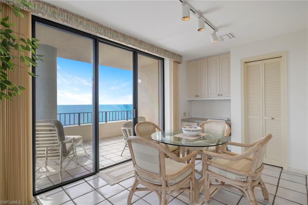 4451 Gulf Shore Boulevard North, Unit 2002 Naples, FL 34103 - Photo 9 of 42 a dining room with furniture and window