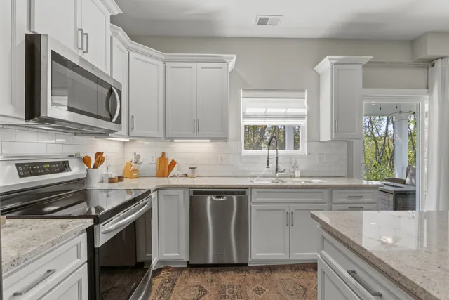 a kitchen with stainless steel appliances granite countertop a sink stove and microwave