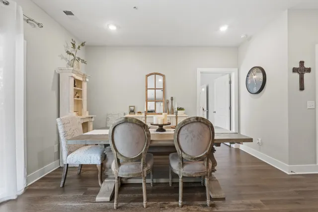 a dining room with wooden floor a glass table and chairs