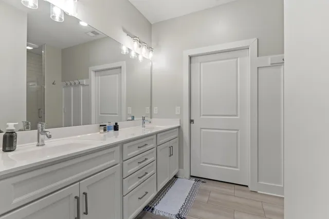 a bathroom with double vanity sink and a mirror