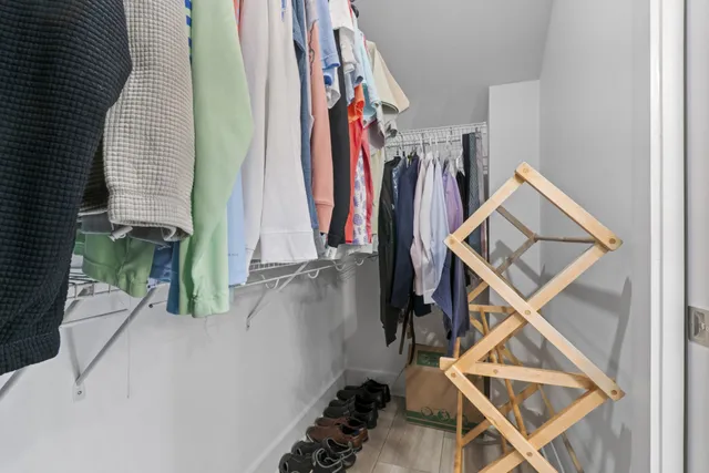 a view of walk in closet with clothes
