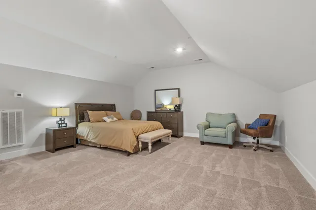 a spacious bedroom with a bed and lamp