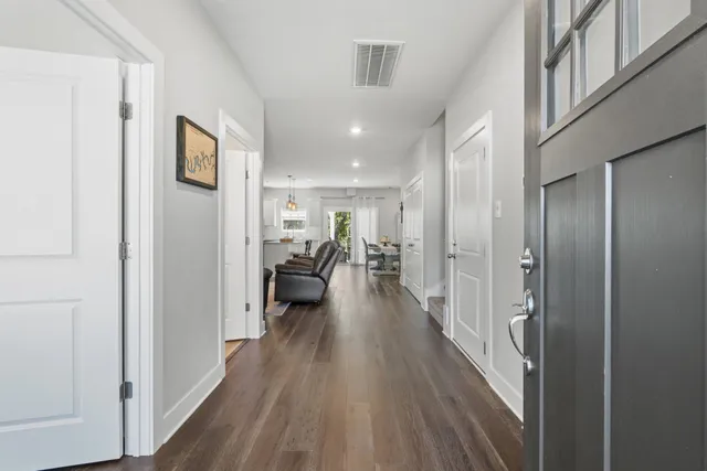 a view of a hallway with wooden floor fireplace and living room