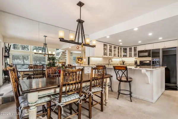 a dining room with furniture and kitchen view