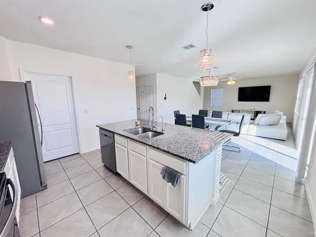 a kitchen with stainless steel appliances granite countertop a sink and a refrigerator
