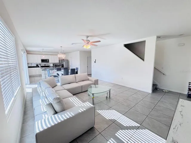 a living room with furniture and a view of kitchen