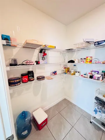 a kitchen with a refrigerator and white cabinets