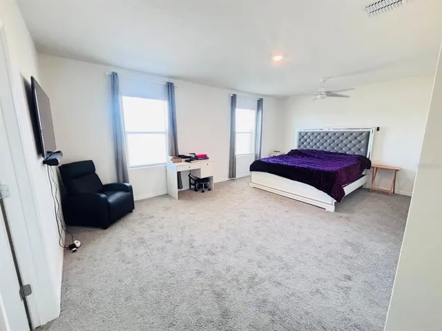 a spacious bedroom with a bed and a couch