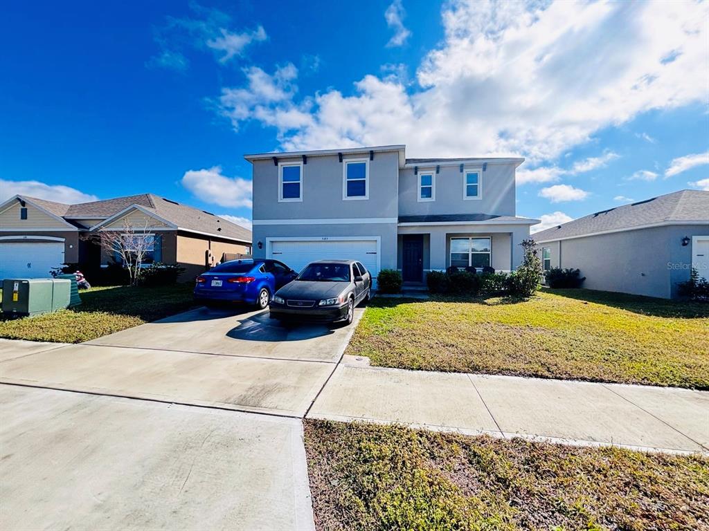 5185 Barombi Bend St. Cloud, FL 34772 - Photo 3 of 47 a front view of a house with a yard
