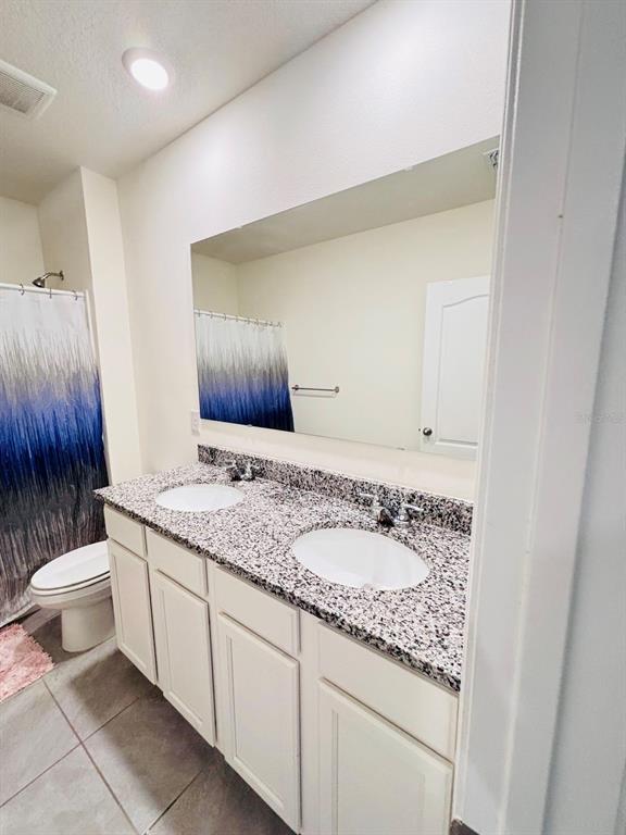5185 Barombi Bend St. Cloud, FL 34772 - Photo 36 of 47 a bathroom with a granite countertop sink and a toilet