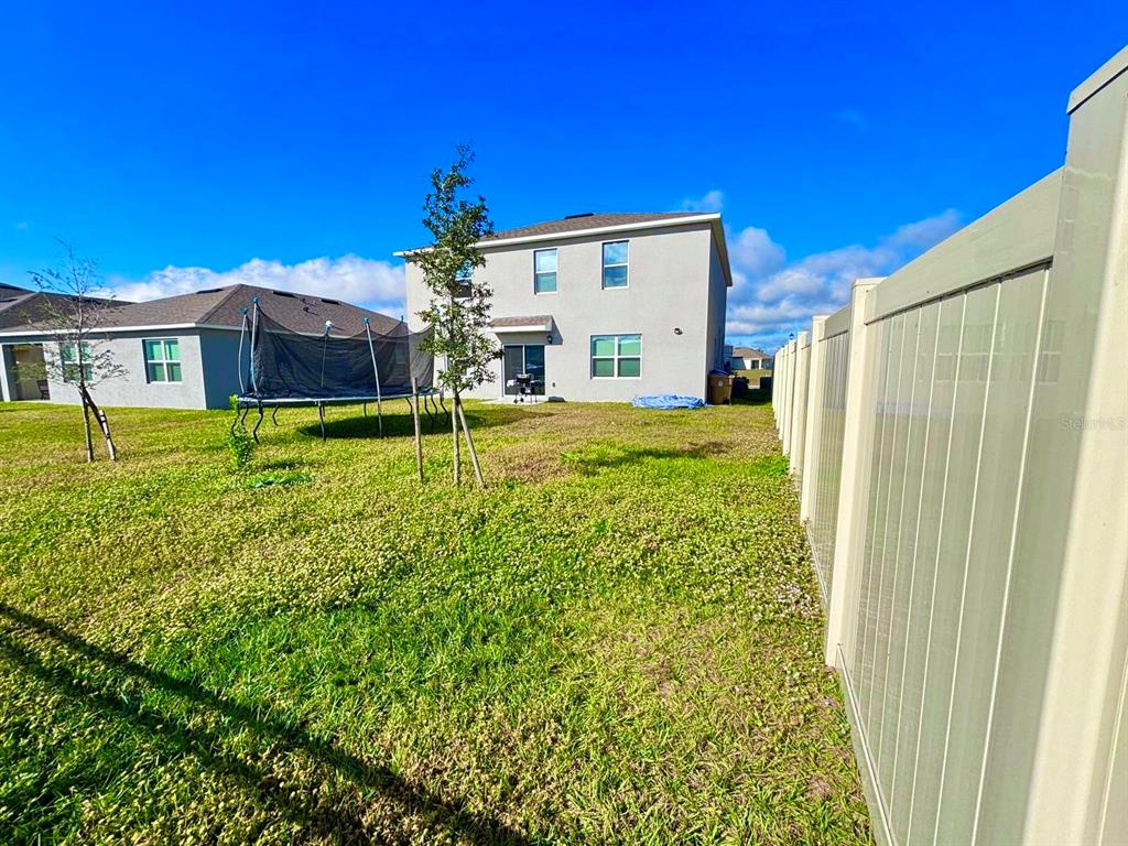 5185 Barombi Bend St. Cloud, FL 34772 - Photo 4 of 47 a backyard of a house with table and chairs