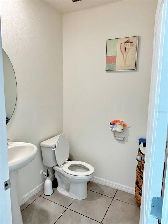 5185 Barombi Bend St. Cloud, FL 34772 - Photo 10 of 47 a white toilet sitting next to a bathroom sink