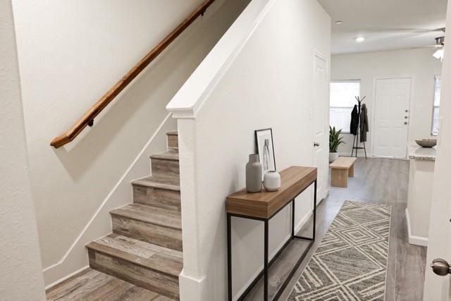 802 South 5th Street, Unit 1 Bonham, TX 75418 - Photo 8 of 25 Staircase with wood-finish treads and risers, complemented by a solid wood handrail