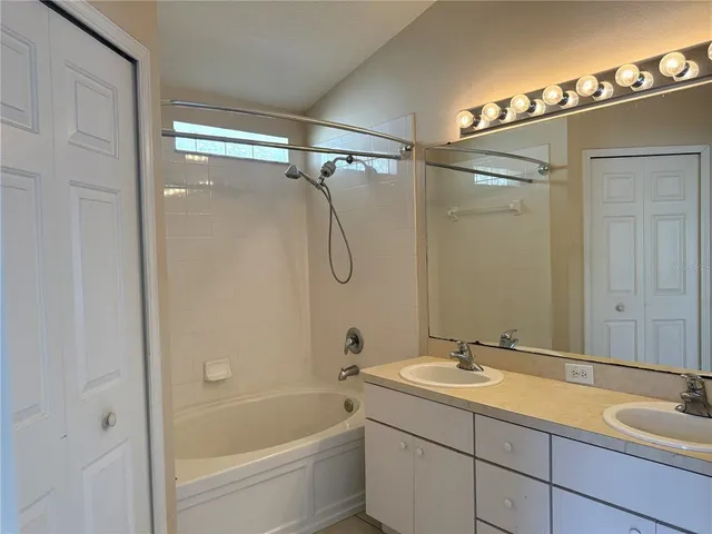 a bathroom with a tub sink shower and mirror
