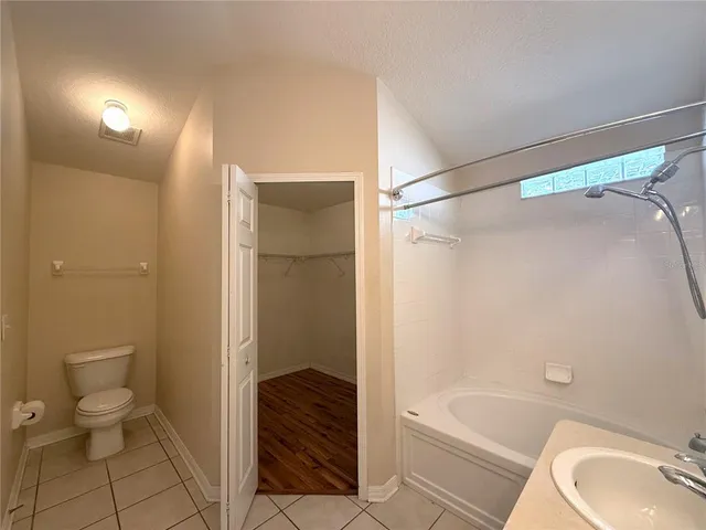 a bathroom with a granite countertop bathtub shower sink and toilet