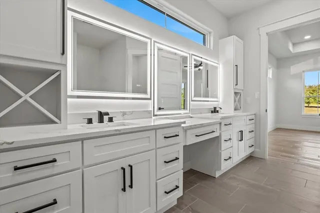 a bathroom with a granite countertop sink vanity and mirror