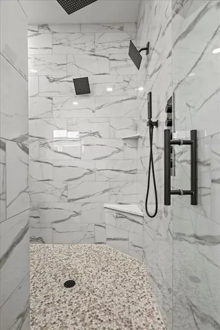 a white bath tub sitting in a bathroom and mirror