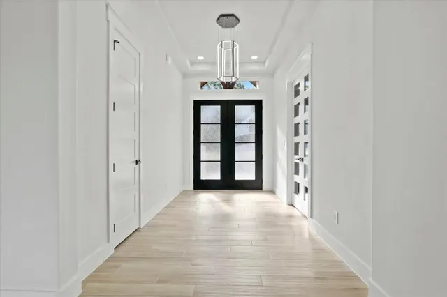 a view of a room with a front door and wooden floor