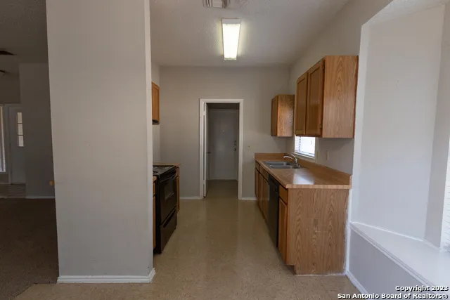 a kitchen with granite countertop a sink and a stove top oven
