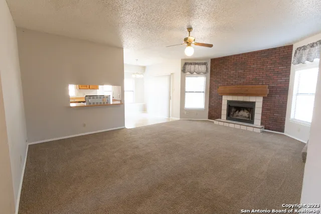 a view of empty room with fireplace and window