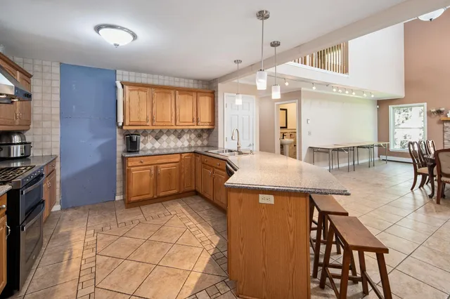 a kitchen with stainless steel appliances kitchen island granite countertop a sink and cabinets