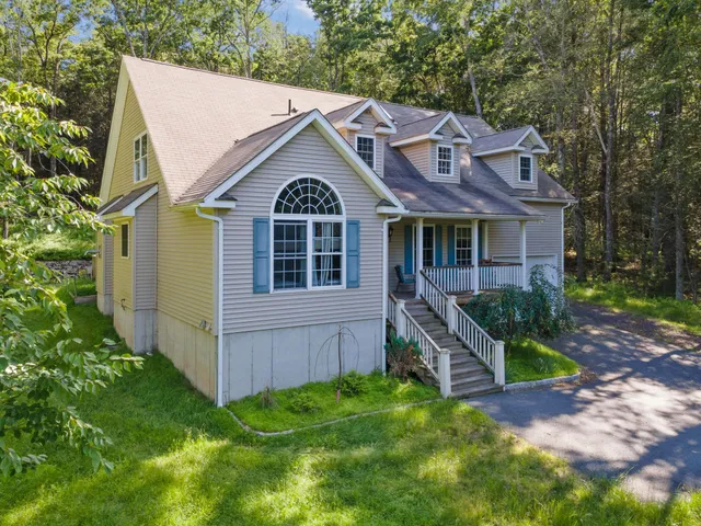 a view of a big house with a big yard plants and large trees