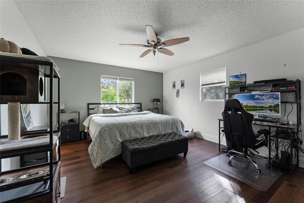2935 Aein Road Orlando, FL 32817 - Photo 10 of 27 a bedroom with a bed a chair and wooden floor