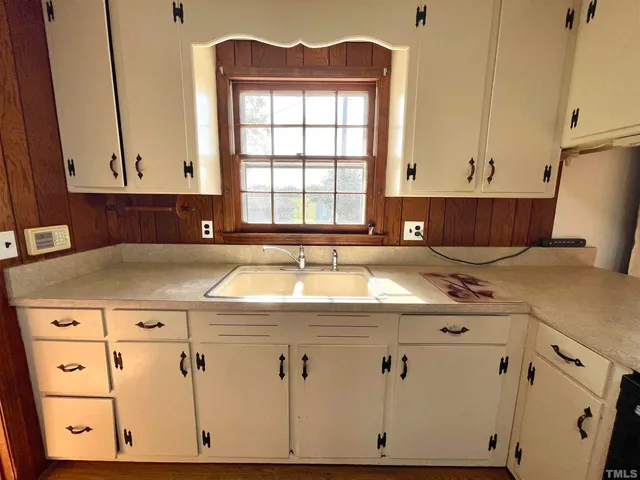 a kitchen with a sink cabinets and a window